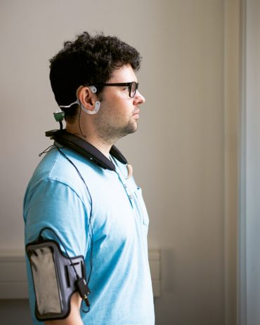 Mit Ohr-EEG, Nacken­lautsprecher und Smartphone am Arm erforscht Daniel Hölle die Wirkung leiser Geräusche auf die Hirnaktivität